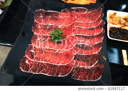Sliced beef shabu in a black plate in a restaurant Sliced beef shabu in a black plate in a restaurant 82982117