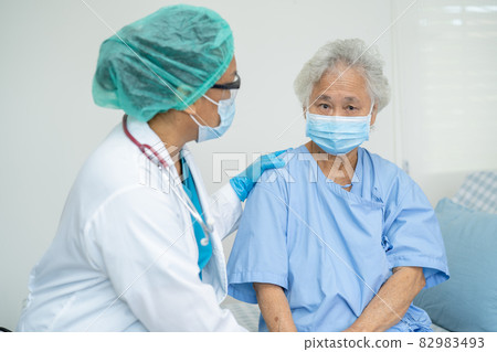 Doctor help Asian senior or elderly old lady woman patient wearing a face mask in hospital for protect safety infection and kill Covid-19 Coronavirus. Doctor help Asian senior or elderly old lady woman patient wearing a face mask in hospital for protect safety infection and kill Covid-19 Coronavirus. 82983493