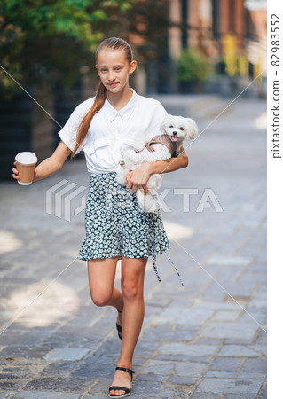 Little smiling girl playing and hugging puppy in the park Little smiling girl playing and hugging puppy in the park 82983552