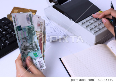 The issue of wages in Russia. Accountant cashier counts the money in rubles and fills the reports and statements. Office worker in the workplace. 82983559