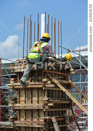 MALACCA, MALAYSIA -MARCH 25, 2016: Construction workers fabricating timber form work at the construction site in Malacca, Malaysia. The form work was mainly made from timber and plywood.  82983639