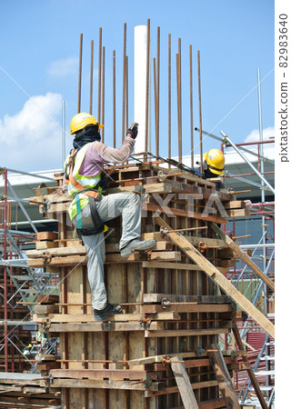 MALACCA, MALAYSIA -MARCH 25, 2016: Construction workers fabricating timber form work at the construction site in Malacca, Malaysia. The form work was mainly made from timber and plywood.  82983640