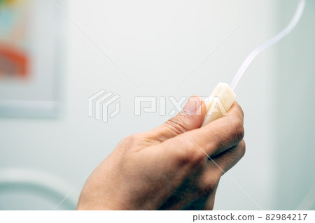 Close up hand holding and adjusting sliding infusion saline Close up hand holding and adjusting sliding infusion saline 82984217