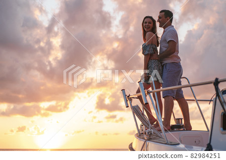 Beautiful couple looking at sunset from the yacht 82984251