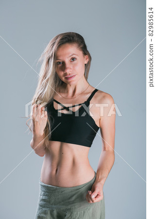 Fitness girl with sporty body posing at studio on grey background. Fitness smiling model in sportswear. Weight Loss. Healthy lifestyle. Sporty healthy female. Fitness girl with sporty body posing at studio on grey background. Fitness smiling model in sportswear. Weight Loss. Healthy lifestyle. Sporty healthy female. 82985614