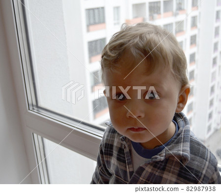 Beautiful baby boy with child face posing photographer near window 82987938