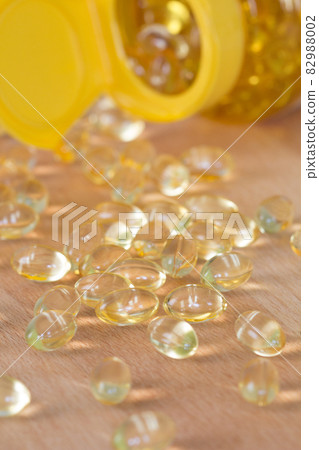 Fish oil omega pills spilled from a bottle 82988002