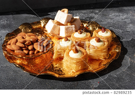 Turkish dessert baklava with nuts on black background Turkish dessert baklava with nuts on black background 82989235