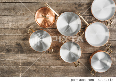 Arrangement of copper cooking pots on old grunge wooden background Arrangement of copper cooking pots on old grunge wooden background 82989518