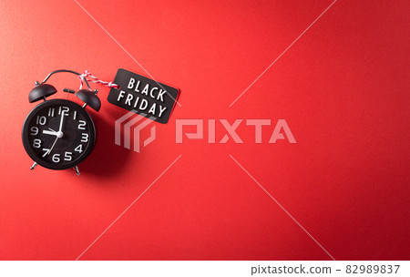 Top view of Black Friday Sale text with Alarm clock on red background. Shopping concept boxing day and Black Friday composition. Top view of Black Friday Sale text with Alarm clock on red background. Shopping concept boxing day and Black Friday composition. 82989837