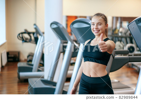 A young woman is engaged in fitness at the GYM. A woman on a treadmill. 82989844