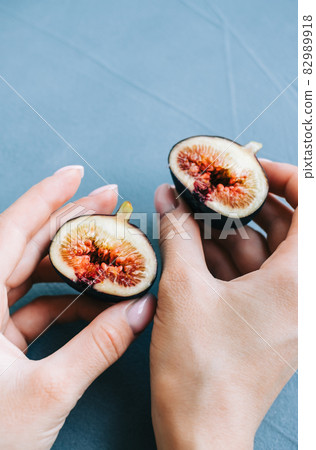 Fresh ripe figs in hand on blue background, close-up. Fresh ripe figs in hand on blue background, close-up. 82989918