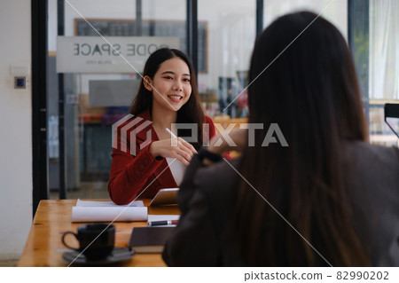 During a job interview, Woman in a suit and gives a presentation about herself. During a job interview, Woman in a suit and gives a presentation about herself. 82990202