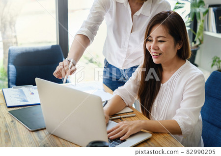 Adult woman teaching her friend to stock trading on laptop application. trade, stock, invest concept. Adult woman teaching her friend to stock trading on laptop application. trade, stock, invest concept. 82990205