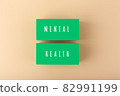 Mental health text written on green blocks on bright beige background 82991199