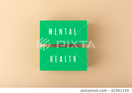 Mental health text written on green blocks on bright beige background Mental health text written on green blocks on bright beige background 82991199