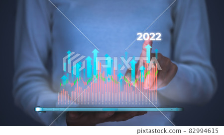Businesswoman pointing to 2022 of business and data analysis over virtual screen on tablet, Increase arrow graph development to success and motivation. Global financial marketing, Growing growth plan. 82994615