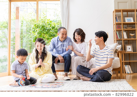 Three-generation family relaxing in the living room 82996822