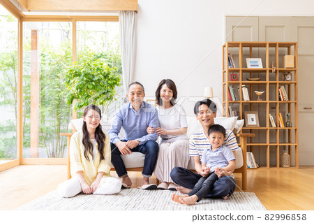 Three-generation family relaxing in the living room 82996858