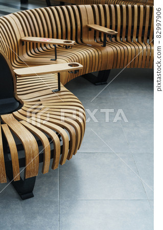 Modern curved wooden bench at the airport Modern curved wooden bench at the airport 82997906