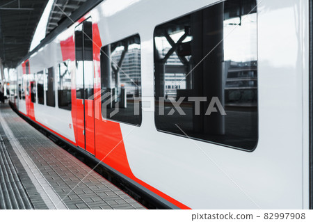 A modern high-speed electric train stands on a platform. A modern high-speed electric train stands on a platform. 82997908
