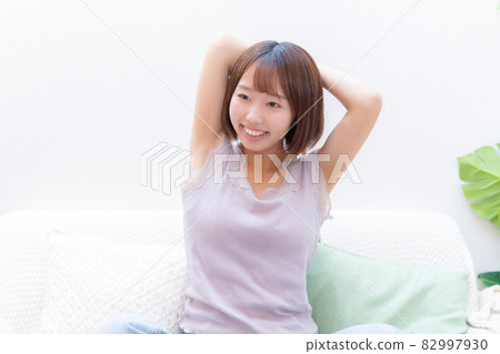 A woman who stretches with her arms raised A woman who stretches with her arms raised 82997930