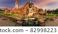 Ruins of buddha statue and pagoda on colorful background, Scenic view of Thai historical buddha statue and pagoda at dusk,  Buddha statue and ruins of a pagoda at Ayutthaya historical park 82998223