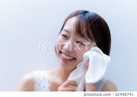 一個微笑的女人用毛巾擦臉 82998741
