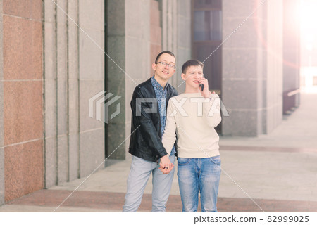 Cute gay couple in the city, tender gentle kissing, smiling Cute gay couple in the city, tender gentle kissing, smiling 82999025