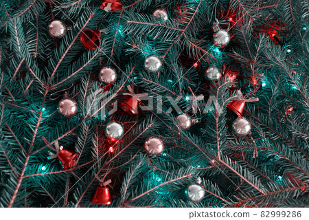 christmas background with fir branches, christmas tree, golden balls, red bells, colored lights 82999286