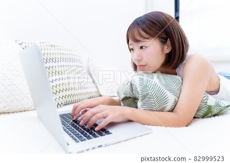 面朝下笑著操作電腦的女人 面朝下笑著操作電腦的女人 82999523