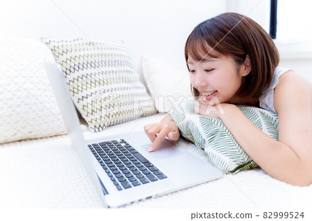 一個女人在床上使用陌生的電腦 一個女人在床上使用陌生的電腦 82999524