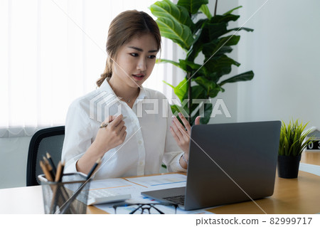 Businesswoman in having a video call on laptop while discussion with business partner during work from home. Businesswoman in having a video call on laptop while discussion with business partner during work from home. 82999717