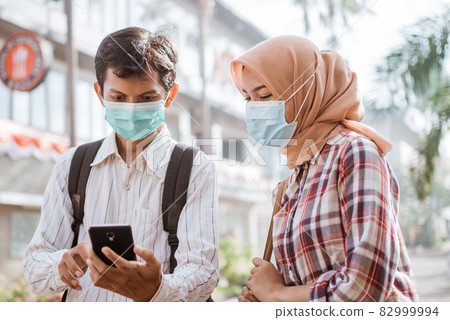 Asian woman and man with medical disposable mask to avoid viruses Asian woman and man with medical disposable mask to avoid viruses 82999994