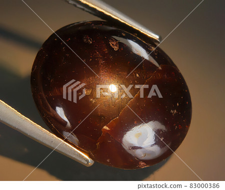 Natural almandine garnet on gray background Natural almandine garnet on gray background 83000386