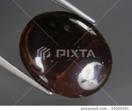 Natural almandine garnet on gray background Natural almandine garnet on gray background 83000391