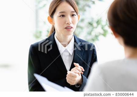 A young woman talking to a person facing her 83000644