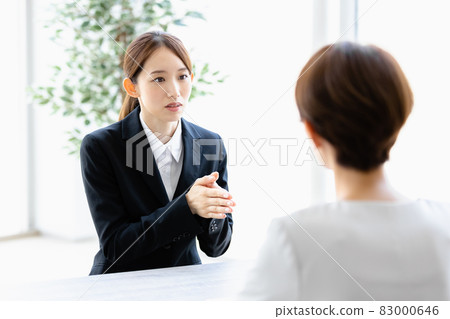 一位年輕女子與面對她的人交談 83000646