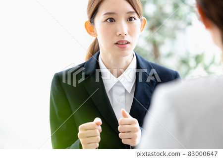 A young woman talking to a person facing her 83000647