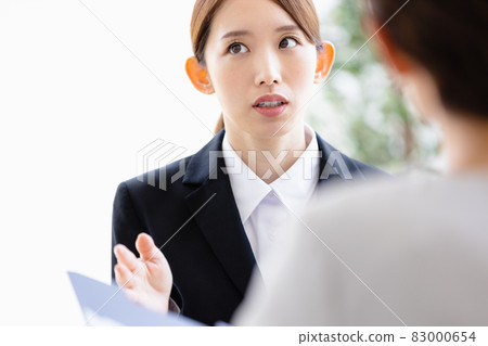 A young woman talking to a person facing her 83000654