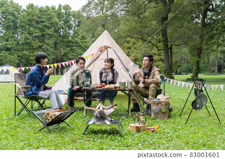 Young men and women enjoying camping 83001601