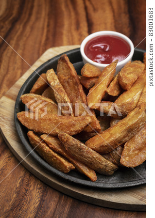 spicy curry powder coated crispy deep fried potato wedges 83001683