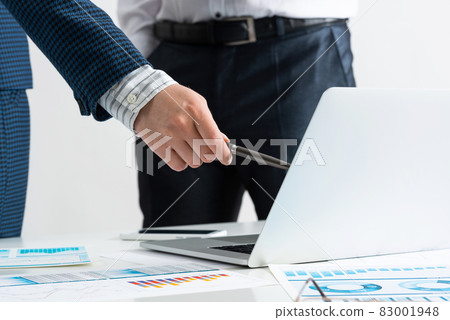 Businessman and businesswoman stand near desk 83001948