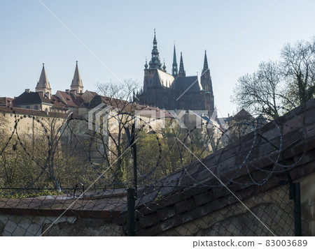 View of Prague Castle and St. Vitus Cathedral gothic churche, Hradcany through barbed wire fence from Queen Annes Summer Palace Belvedere during Covid pandemy lockdown View of Prague Castle and St. Vitus Cathedral gothic churche, Hradcany through barbed wire fence from Queen Annes Summer Palace Belvedere during Covid pandemy lockdown 83003689