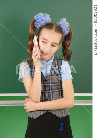Cute girl schoolgirl near blackboard Cute girl schoolgirl near blackboard 83003921