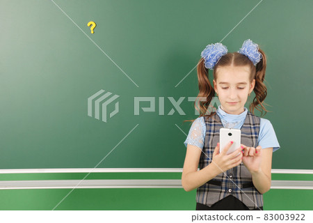 Cute girl schoolgirl near blackboard Cute girl schoolgirl near blackboard 83003922