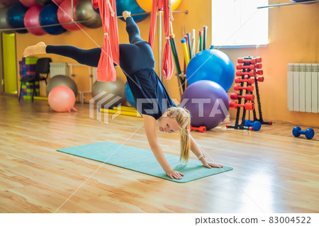 Young beautiful woman practicing aerial yoga in gym. Lifestyle 83004522