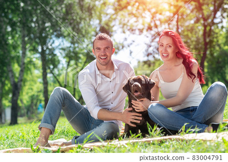Couple with a dog in the park Couple with a dog in the park 83004791