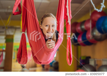 Young beautiful woman practicing aerial yoga in gym. Lifestyle 83005077