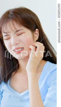 woman scratching her face 83005293